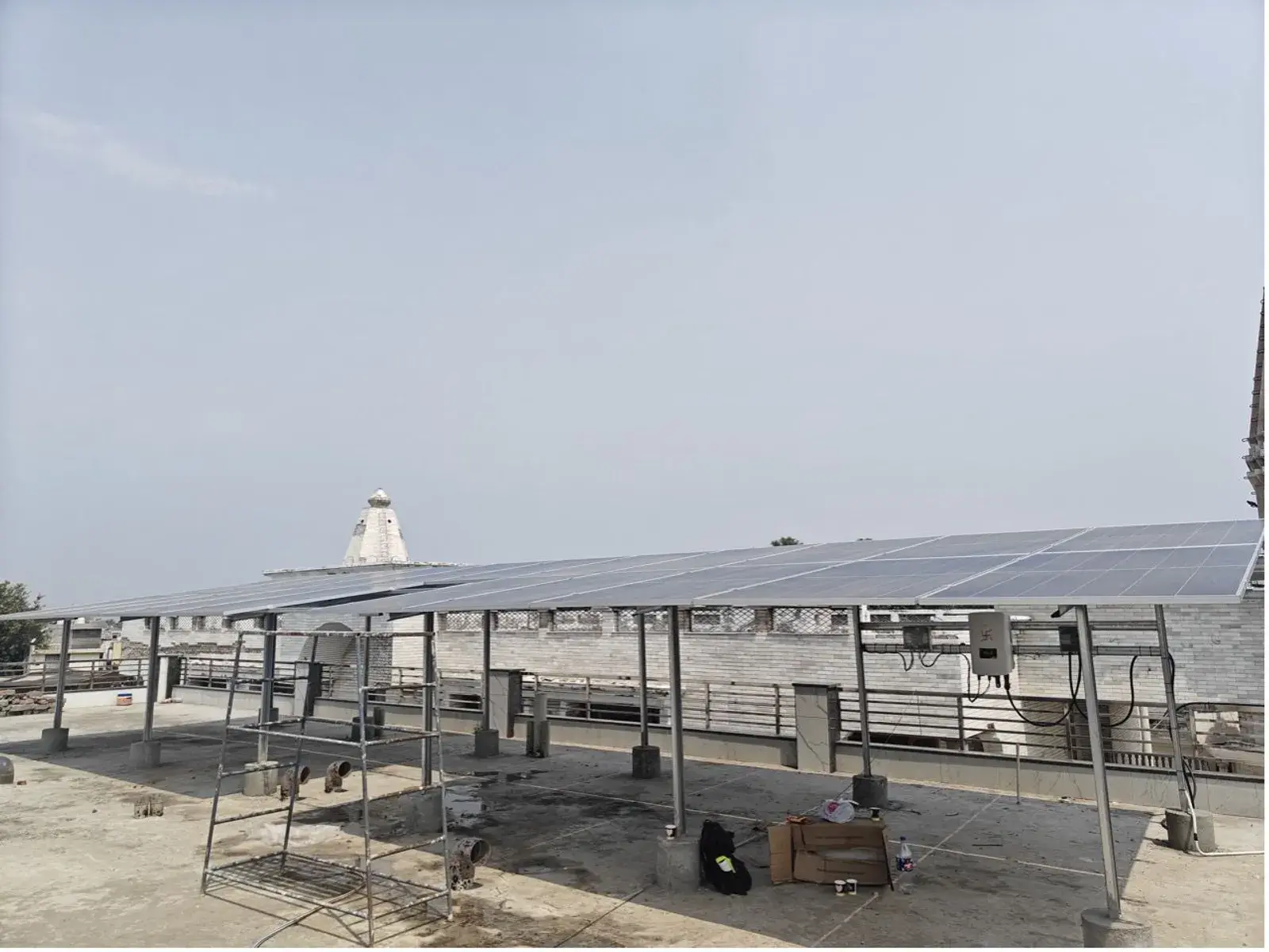 Elevated rooftop solar structure across the Ashram roof