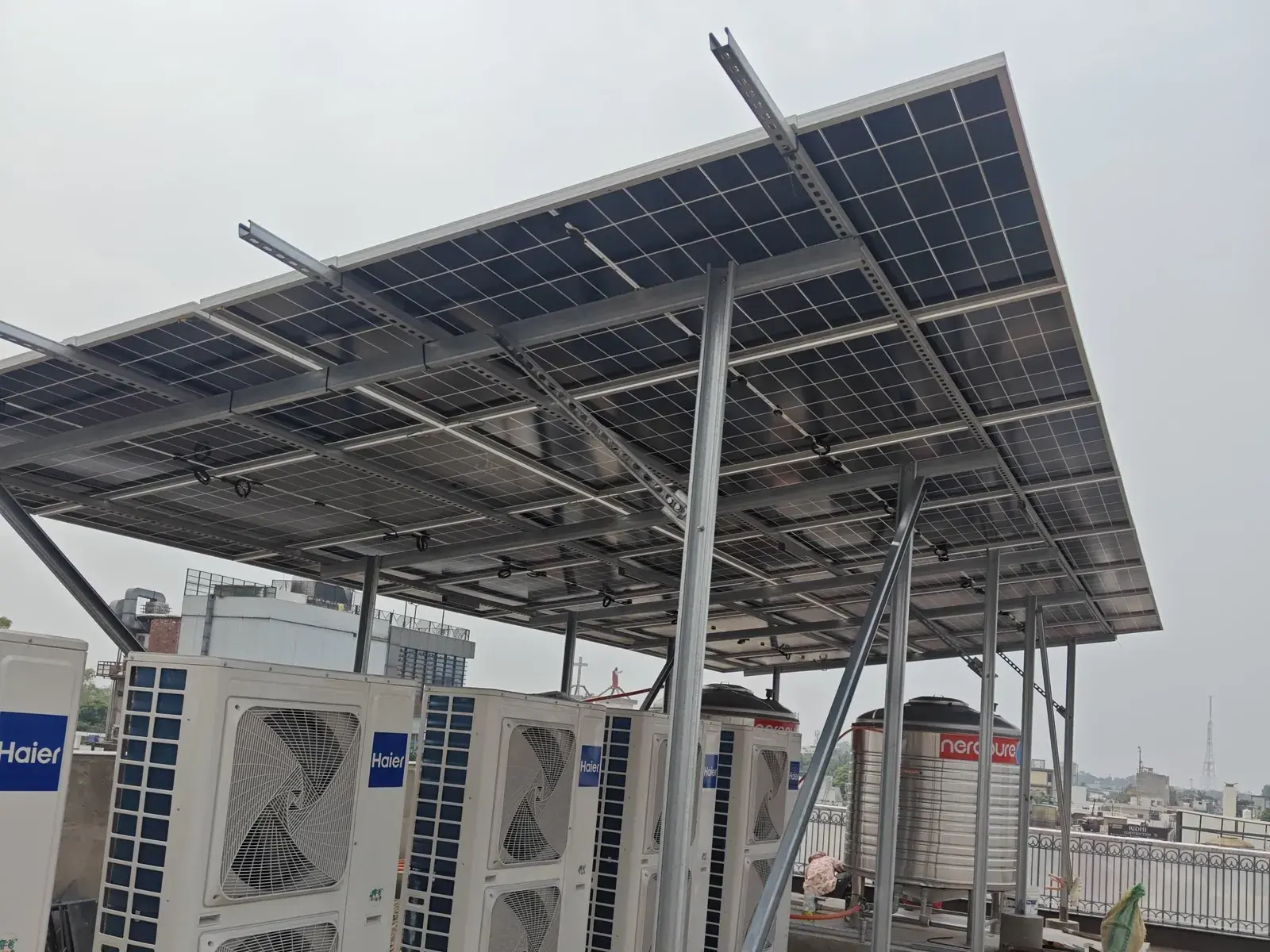 Avaada TOPCon modules on an elevated structure above rooftop AC units