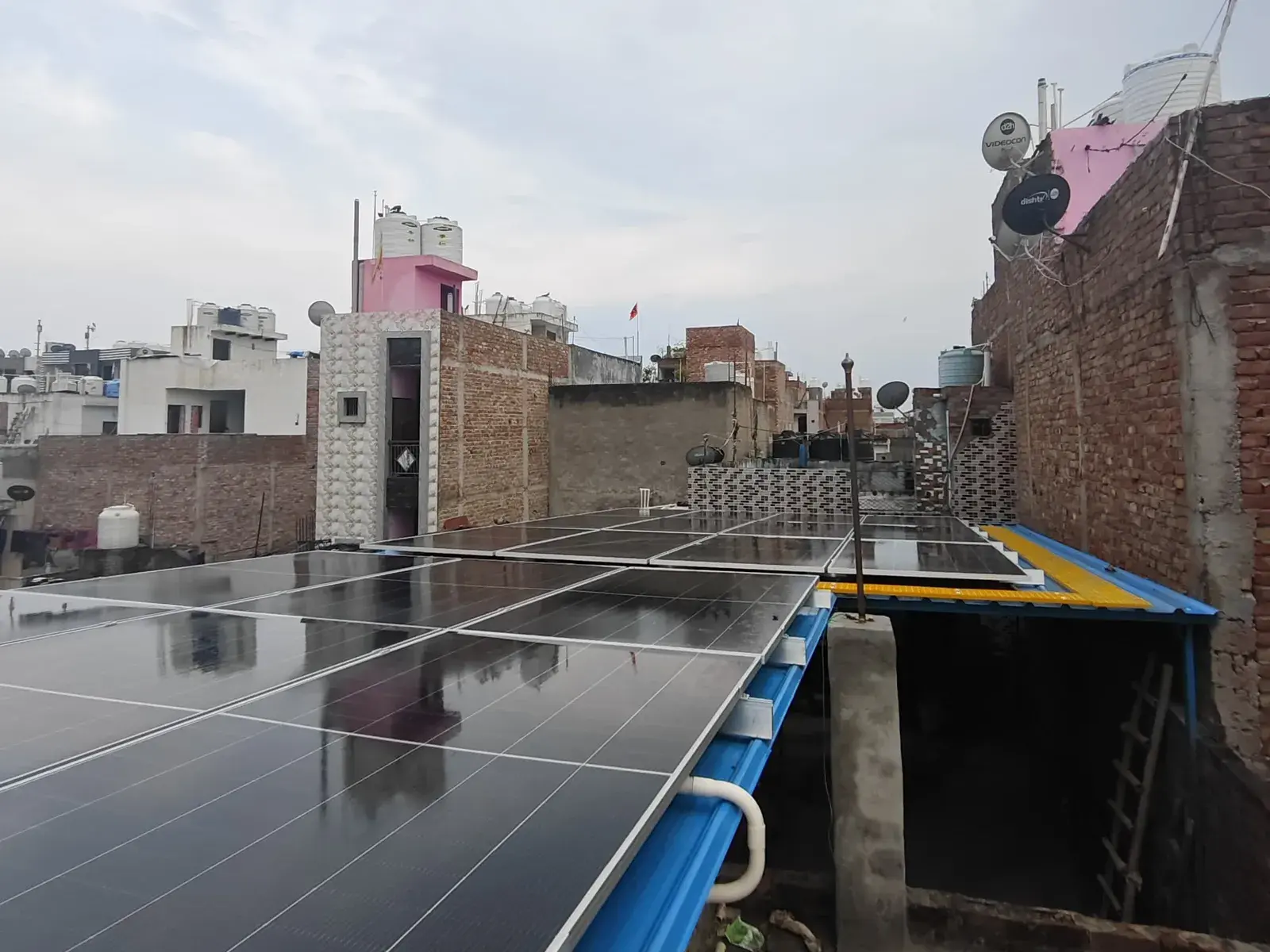 Rooftop solar array on the Verma Footwear tin shed between neighbouring buildings