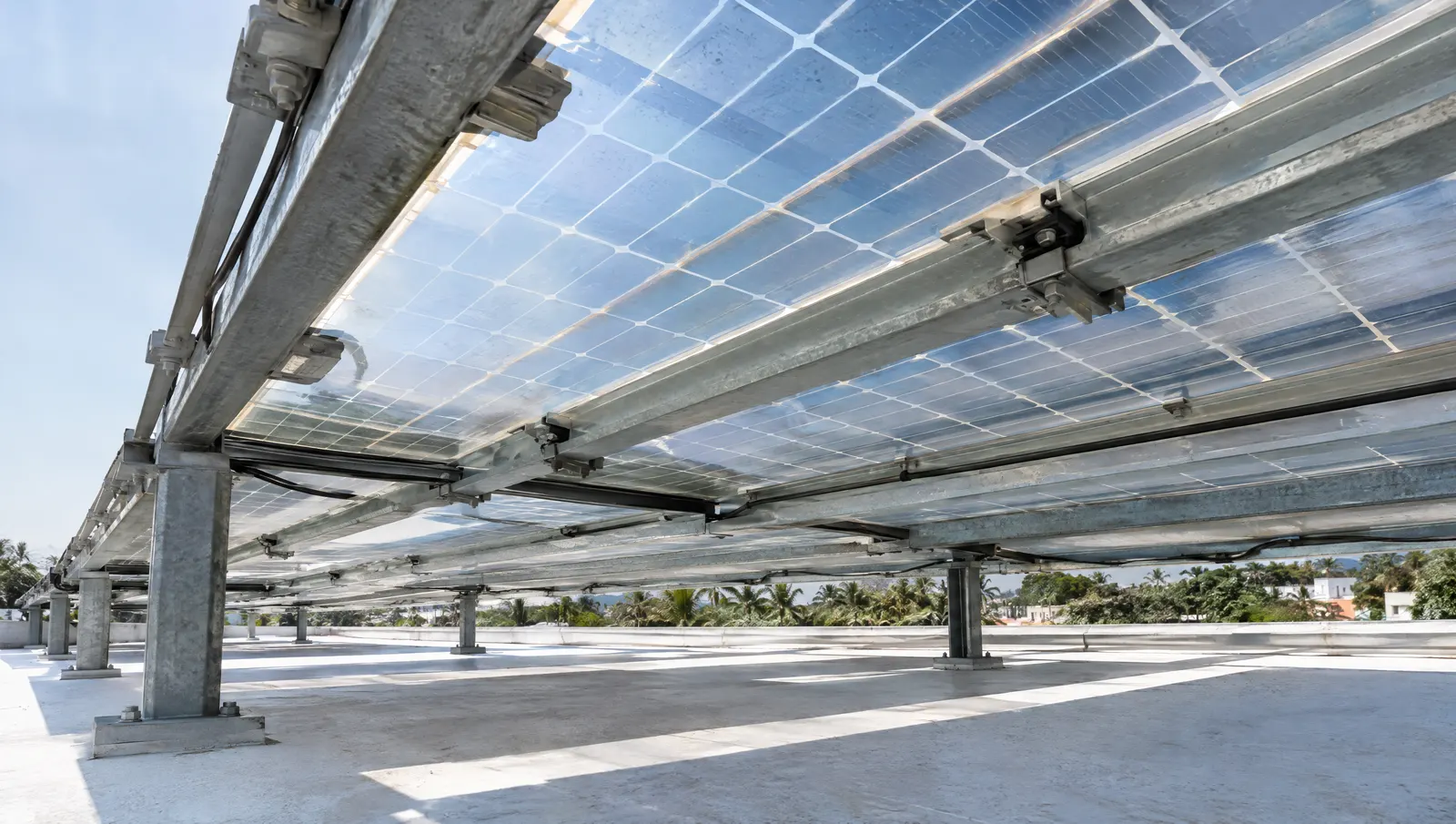 Rear side of elevated bifacial glass-glass modules above a white reflective roof, where light reaching the back of the panel adds generation.